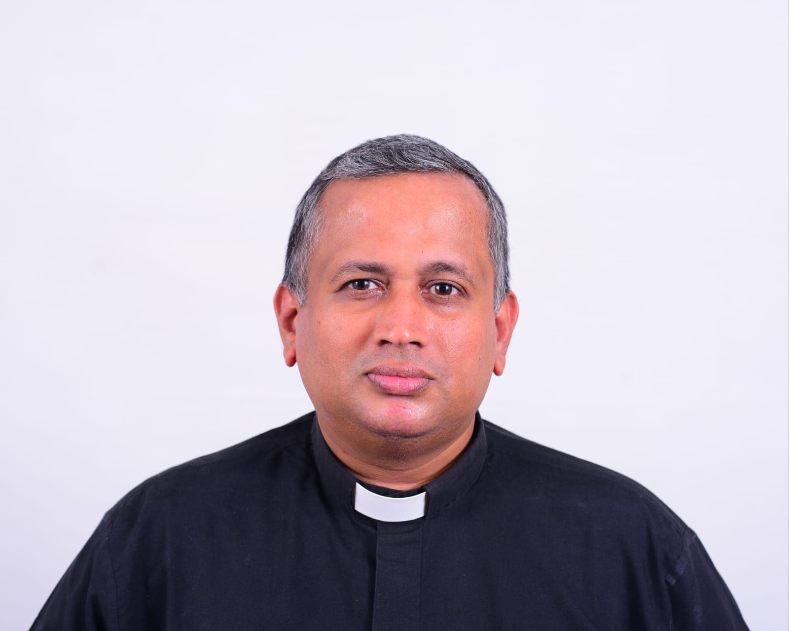 Fr Michael Colin Nixon, Assistant Priest, in a black clerical shirt against a plain background